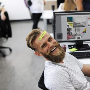 Mann mit Bart lächeln in einem kreativen Büro