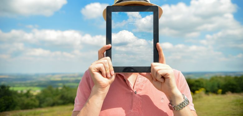 Digital Leadership - Person vor Landschaft mit einem Tablet vor dem Gesicht